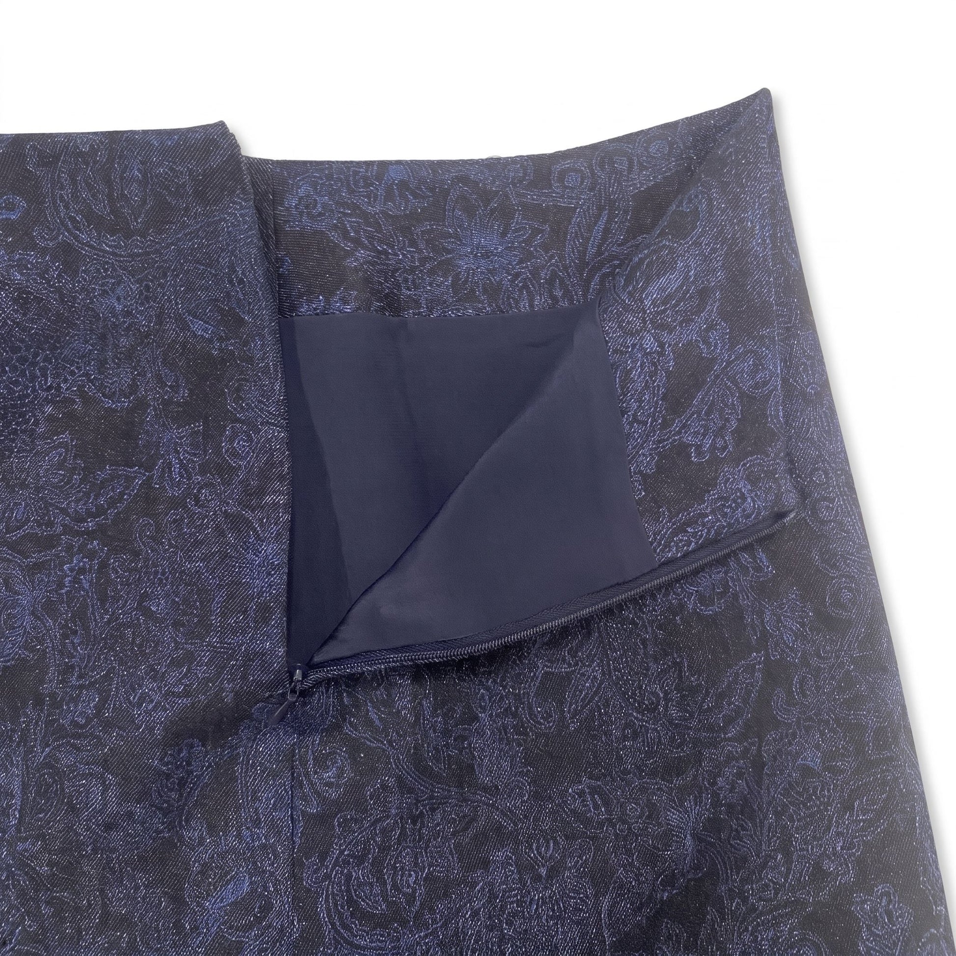 Dettaglio delle cuciture sartoriali e delle finiture della minigonna artigianale in denim blu a fantasia.